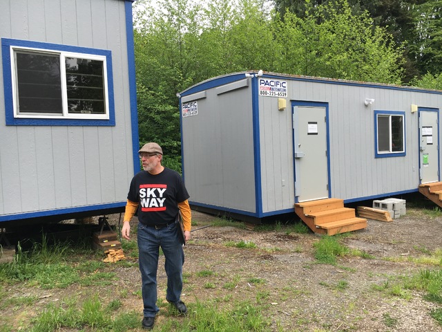 Mark Johnston stands in front of two portable offices that applied for marijuana licenses from the state. Photo by Daniel Person