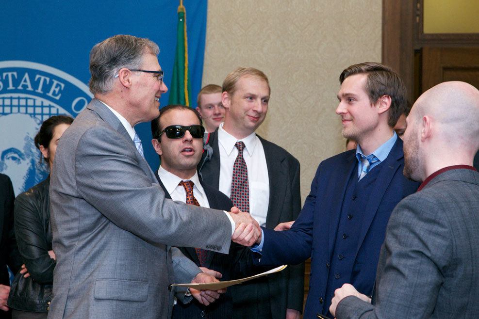 Olson, right, shakes hands with Gov. Jay Inslee. Photo courtesy of Washington State Legislative Support Services
