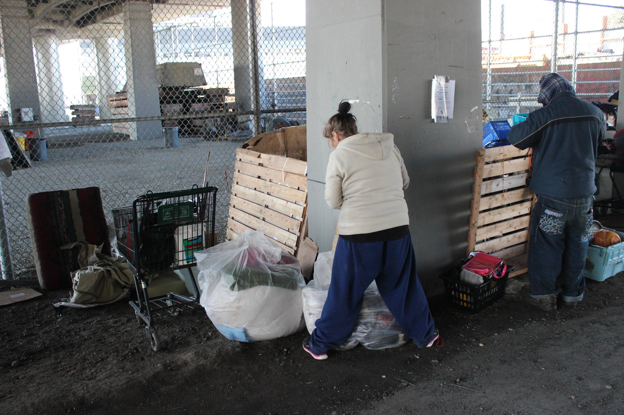 A pair of homeless campers pack up before being evicted from under the Ballard Bridge. Photo by Casey Jaywork.