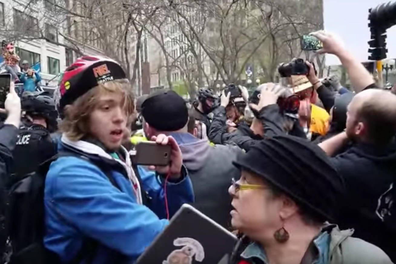 A young man on a bicycle grabs Marti McKenna as she tries to leave Westlake. Screenshot via Youtube/Pat Blo.