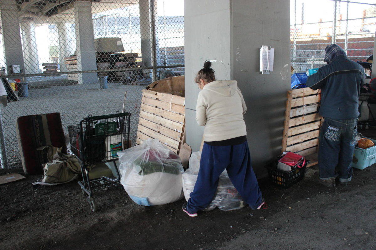 A pair of homeless campers pack up before being evicted from under the Ballard Bridge. Photo by Casey Jaywork
