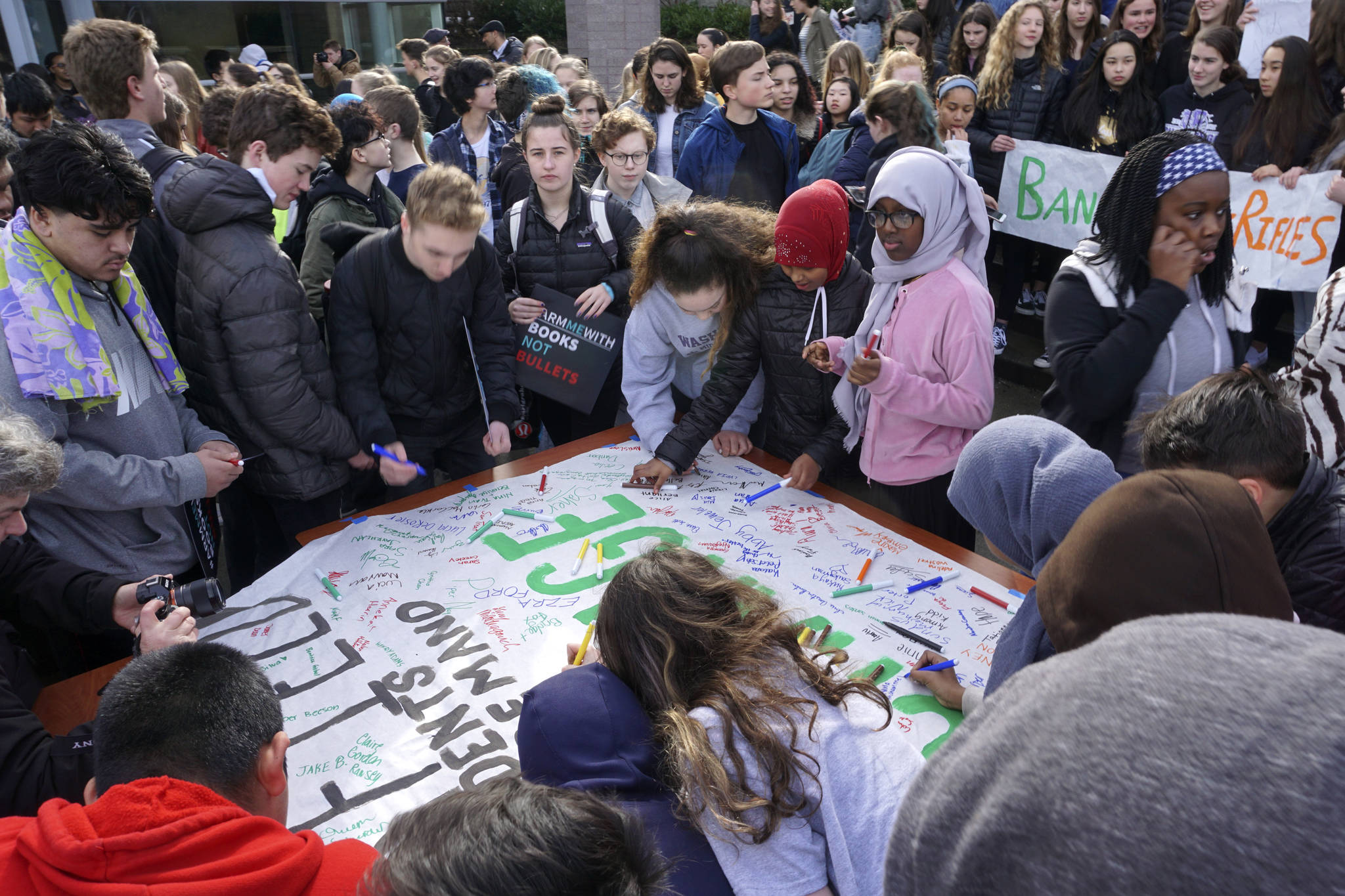 During the walkout, Garfield High School students sign a poster that will be delivered to politicians. Photo by Melissa Hellmann