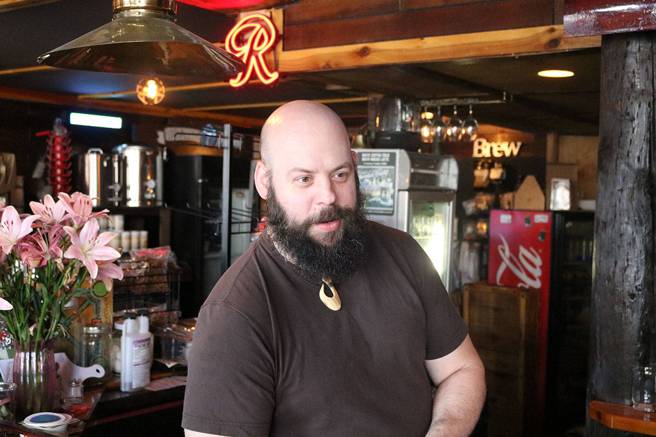 Chris Rohr stands behind the bar at Flood Valley Brewing. Rohr opened the brewery in recent years and hopes to help revitalize the local economy by becoming an anchor business in downtown Chehalis. Photo by Aaron Kunkler