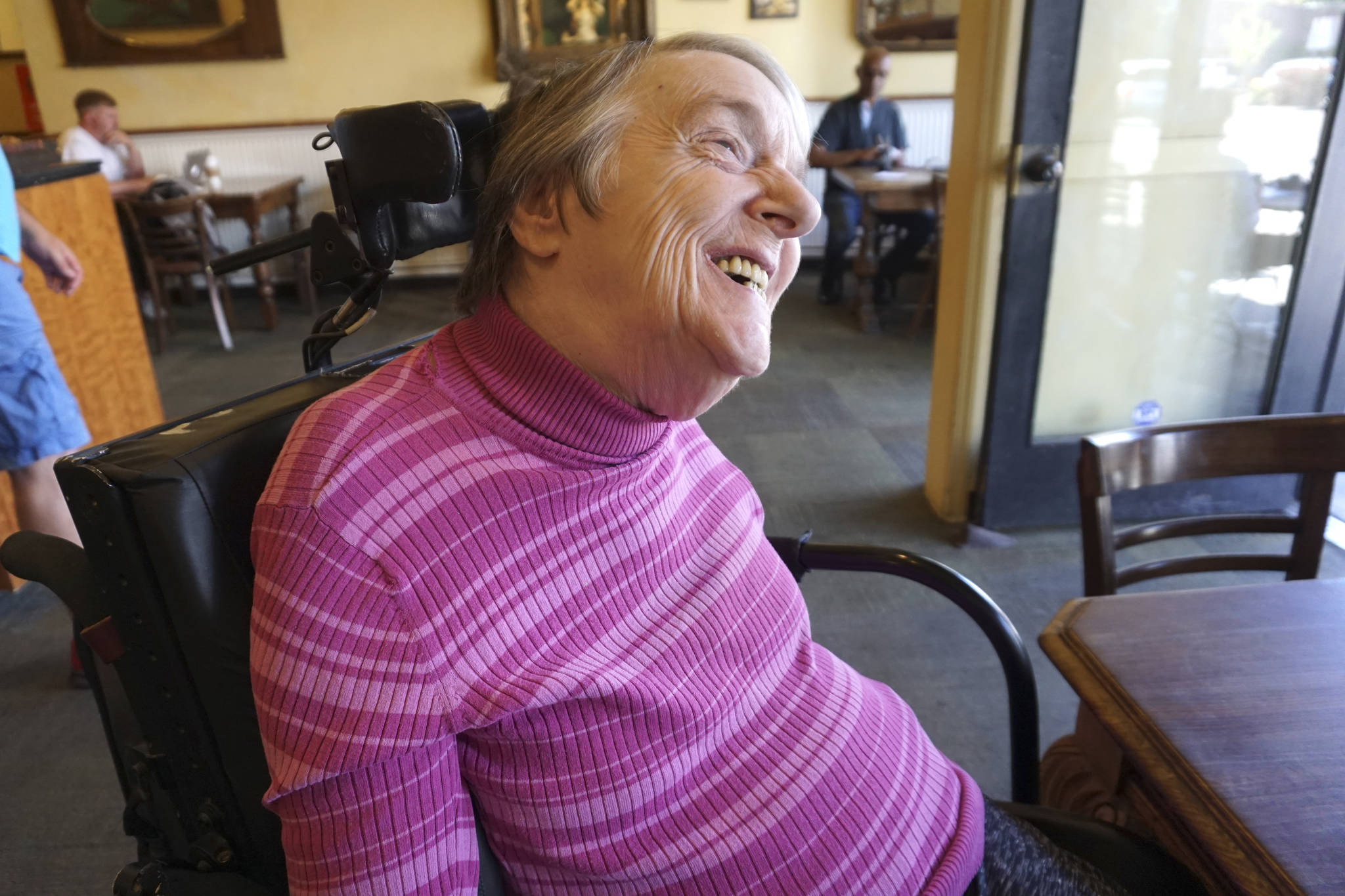 Dianne Laurine, a Commissioner for the Seattle Commission for People with Disabilities says that she needs plastic straws to drink liquids. [Image description: Laurine is wearing a purple turtleneck and smiling.] Photo by Melissa Hellmann