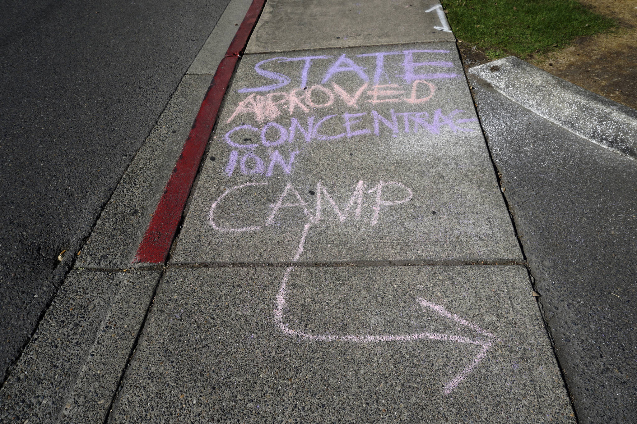 Demonstrators wrote messages on the sidewalk leading to the NWDC on Sep. 1. Photo by Melissa Hellmann