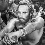 Heston row, row, rows his galley into battle.