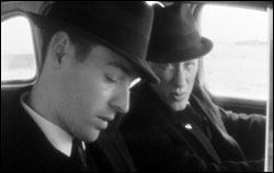 Polish (left) as one of the comic-ominous evacuators, with James Woods.