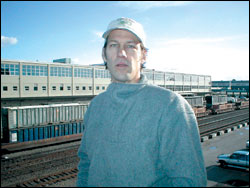 Produce broker Bill Bloxom in SoDo, with the rail yard and the Seattle schools headquarters behind him.
