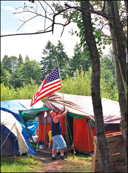 At Tent City 4 in Bothell, Doron Jones tends the flag.