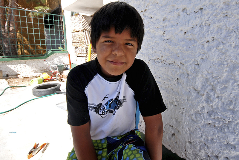 Eight-year-old Esteban, pictured here standing outside his family's house, first saw dead bodies two years ago, in a car four blocks from home.
