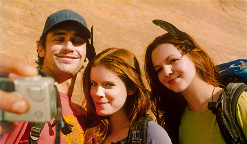 The loner (Franco) meets hikers Kate Mara (center) and Amber Tamblyn.