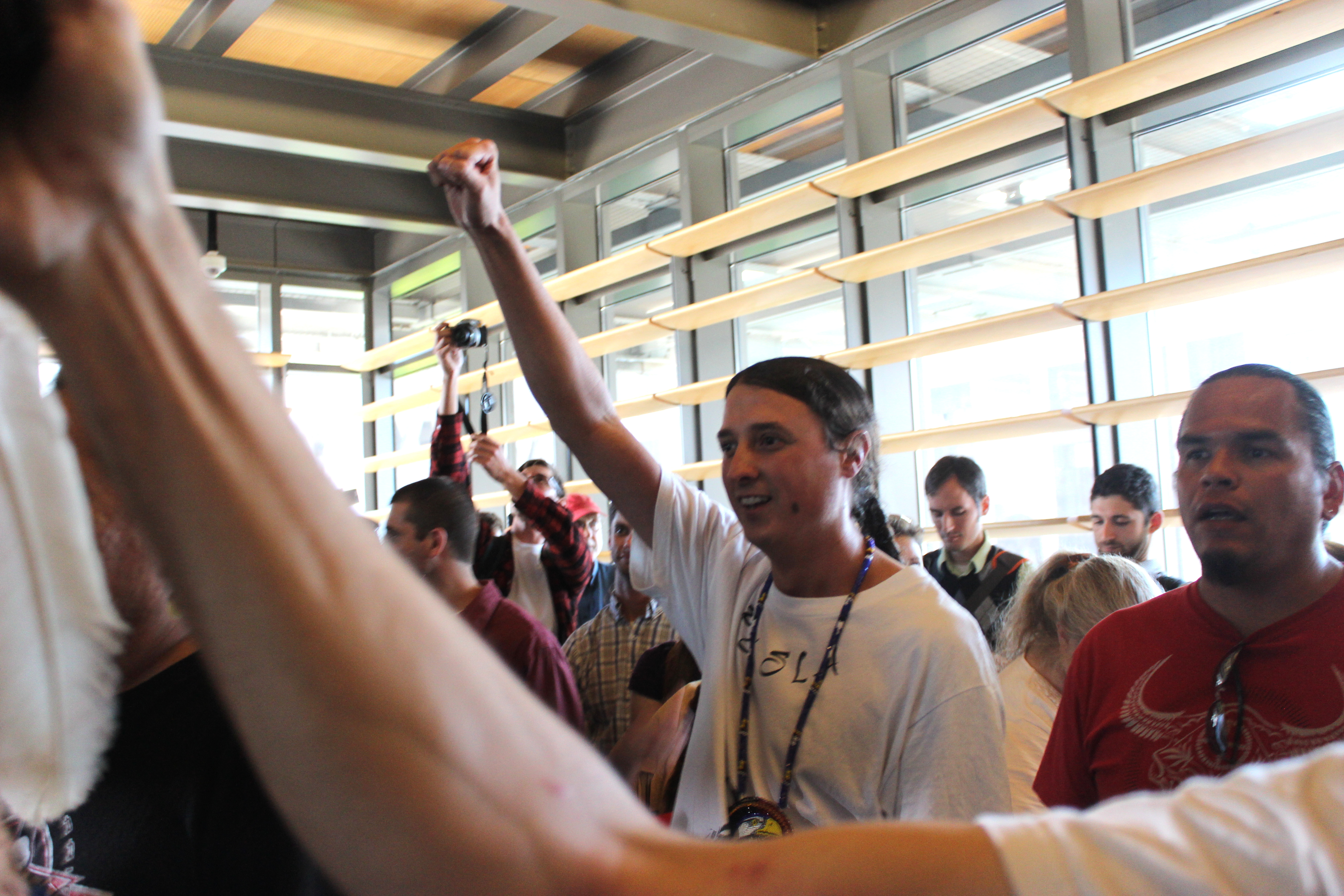 Author of the Indigenous Peoples' Day resolution, Matt Remle, raises his fist after the victory at City Council.