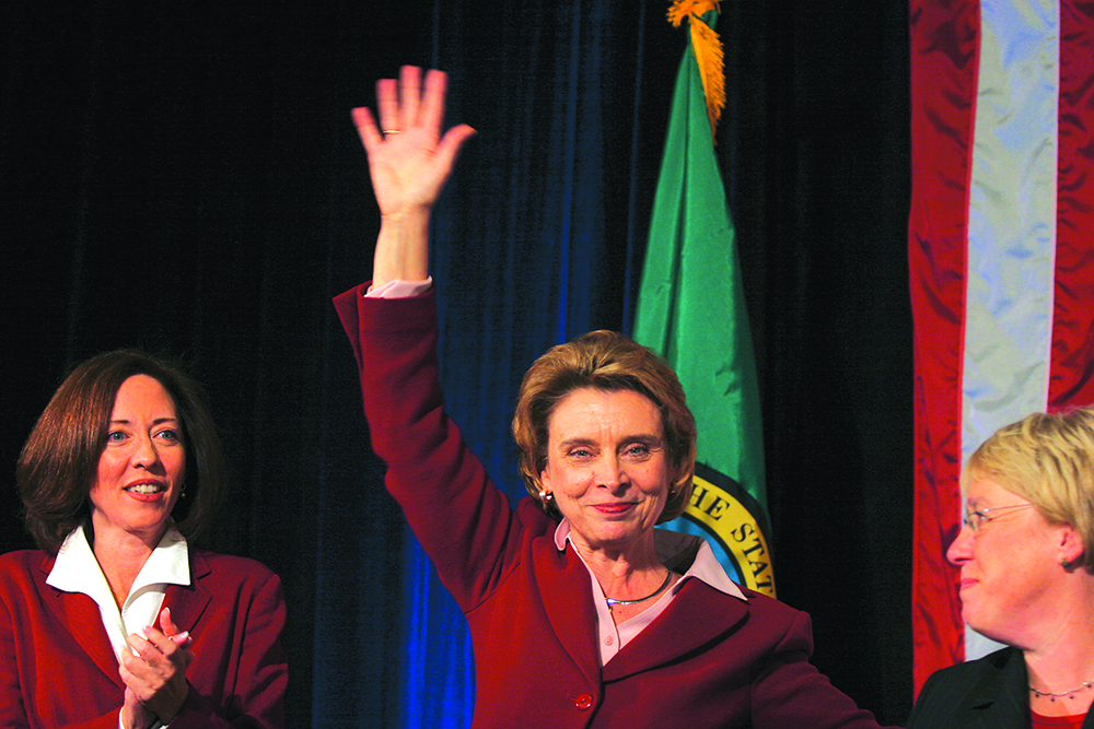 Maria Cantwell, Christine Gregoire and Patty Murray gather on the stage as Gregoire makes some comment about the close race.