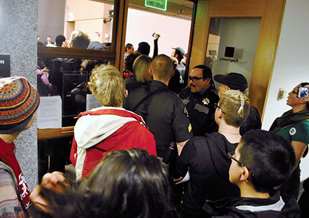 Police guard the entrance to the King County Council chambers during the February 9 hearing. Photo by Celia Berk