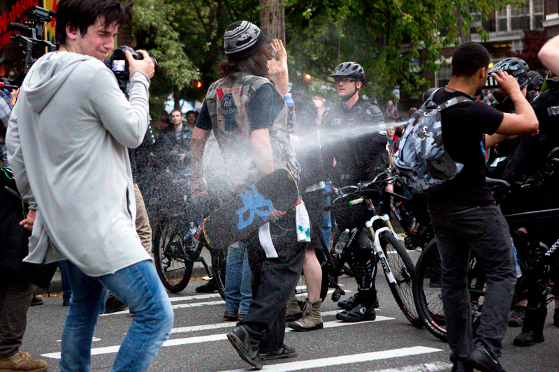 Pepper spray flies again, hitting several protesters directly.