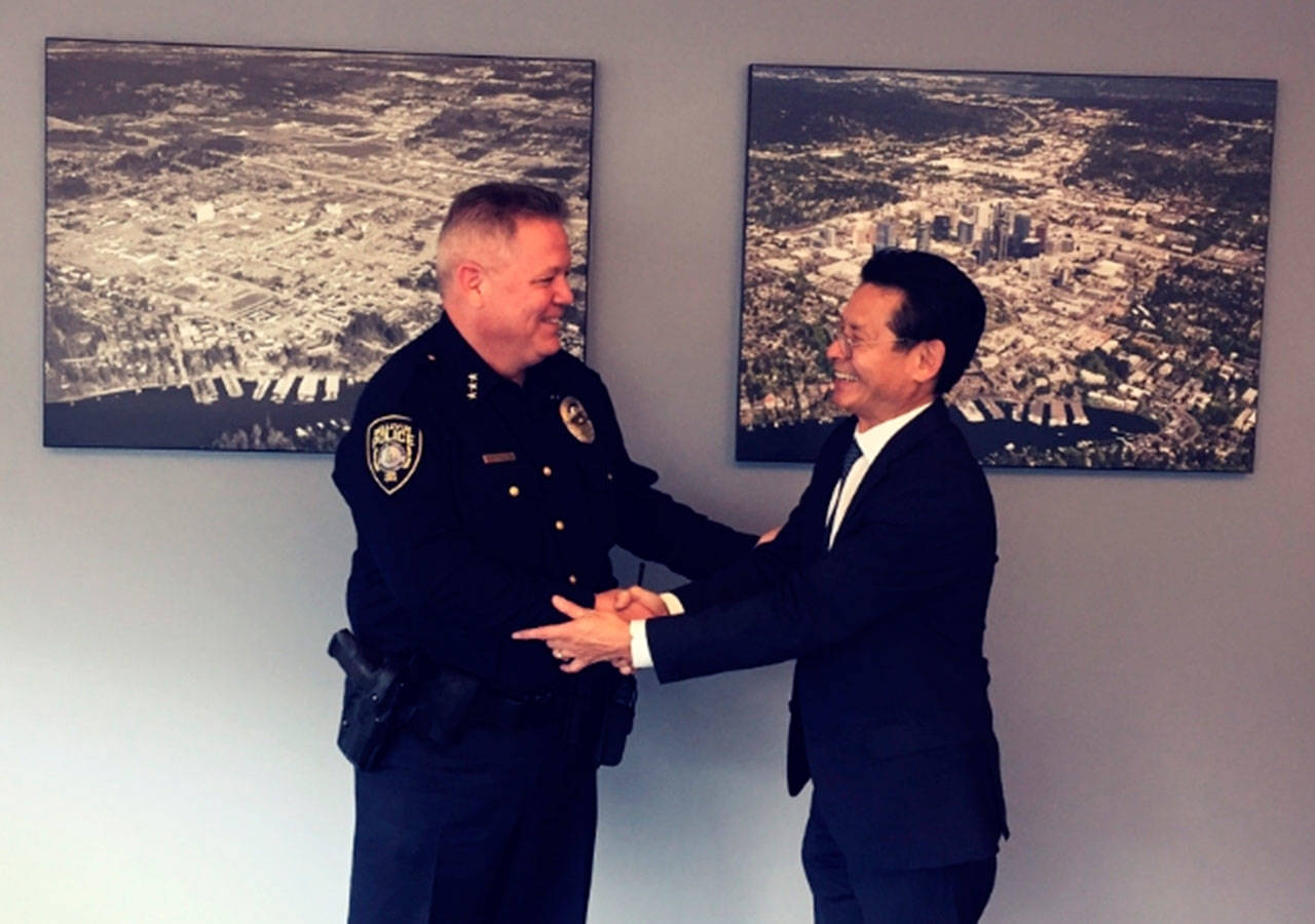 Bellevue city manager Brad Miyake welcomes Steve Mylett back to his position as police chief following his exoneration. Photo courtesy of the city of Bellevue