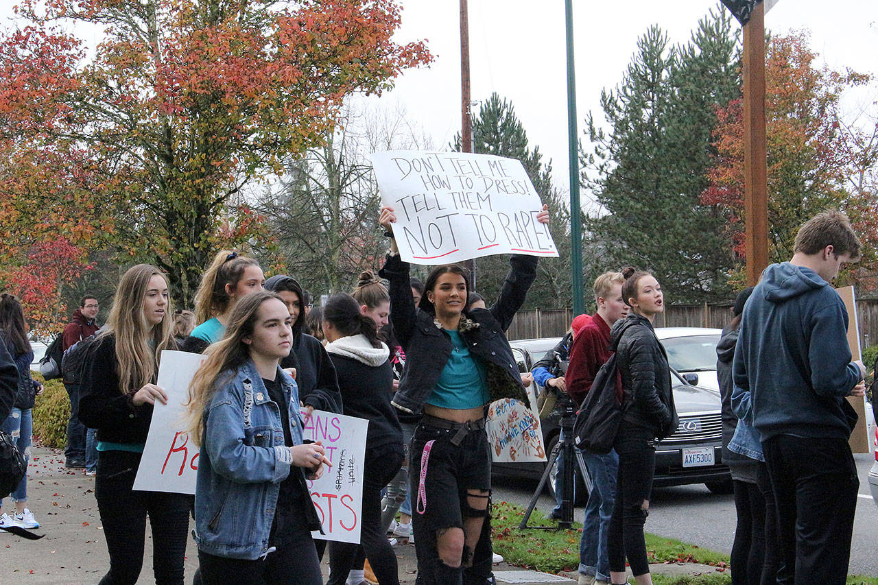 Skyline High School students and community protest perpetuation of rape culture following ISD lawsuit. Left: Chloe Strandwold, senior and organizer of protest; center: Amelia Danyuk, senior, holds sign saying “Don’t Tell Me How to Dress! Tell Them Not to Rape.” Photo by Madison Miller