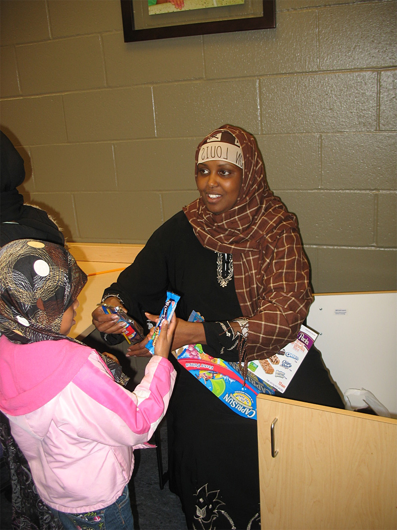 Ubax Gardheere hands out snacks at an after-school tutoring program.