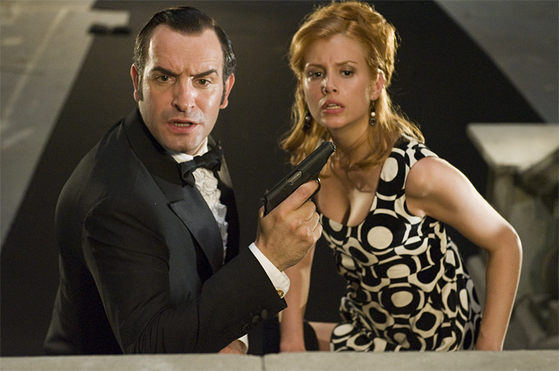 Dujardin’s dimwit attempts to protect the girl (Louise Monot).