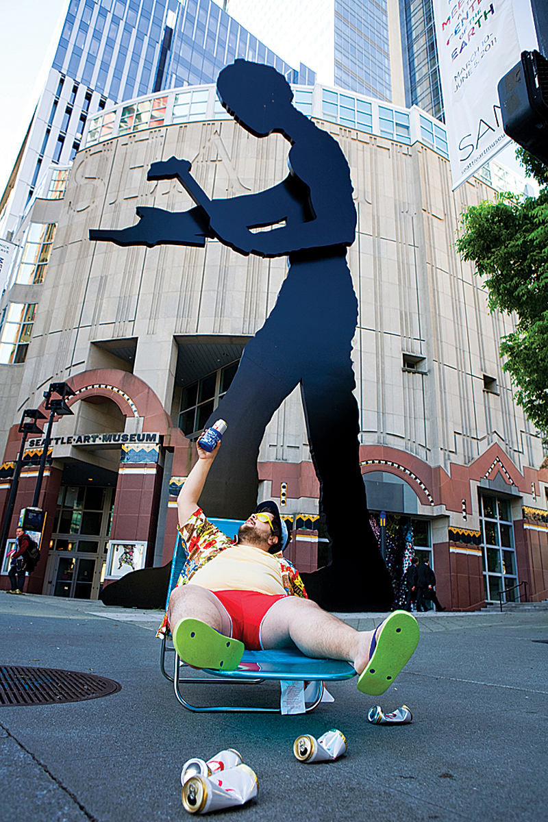 Background: Hammering Man, hammering. Foreground: Adam Firestone, getting hammered.