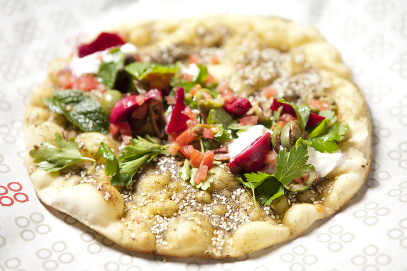 Ma'noushe isn't as familiar to American eaters as hummus or falafel, so Mamnoon's trying to stoke the preparation's local reputation by serving it at dinnertime, neatly rolled and quartered. (Other concessions to western expectations include ma'amoul, customarily a filled blimp of a cookie, remade as a tart.) Ma'noushe is very much a street snack, so the tactic is tantamount to putting croque monsieurs on a menu dominated by duck a l'orange and sole meuniere. But the restaurant is hereby permitted to do whatever it takes to sell more of its wonderfully satisfying man'oushe at its glassed-in takeout counter, which occupies the front half of the restaurant.