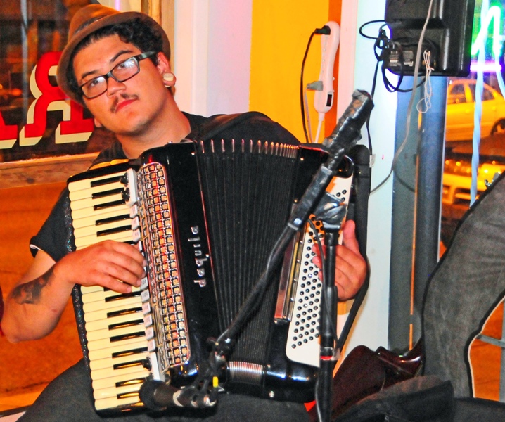 Onstage, Ben Clark, a bandmate of Drew Kenakedes and Joe Albanese, plays accordion.
