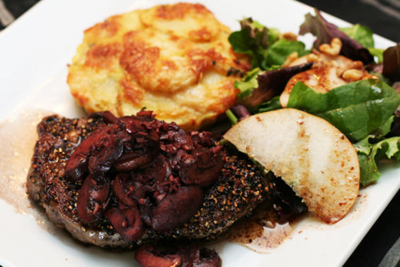 What are you trying to hide there, steak? Pepper-seared steak next to a cheesy potato galette with a mixed green salad covered in a truffle oil vinaigrette from Chow Bella in Phoenix, Arizona.