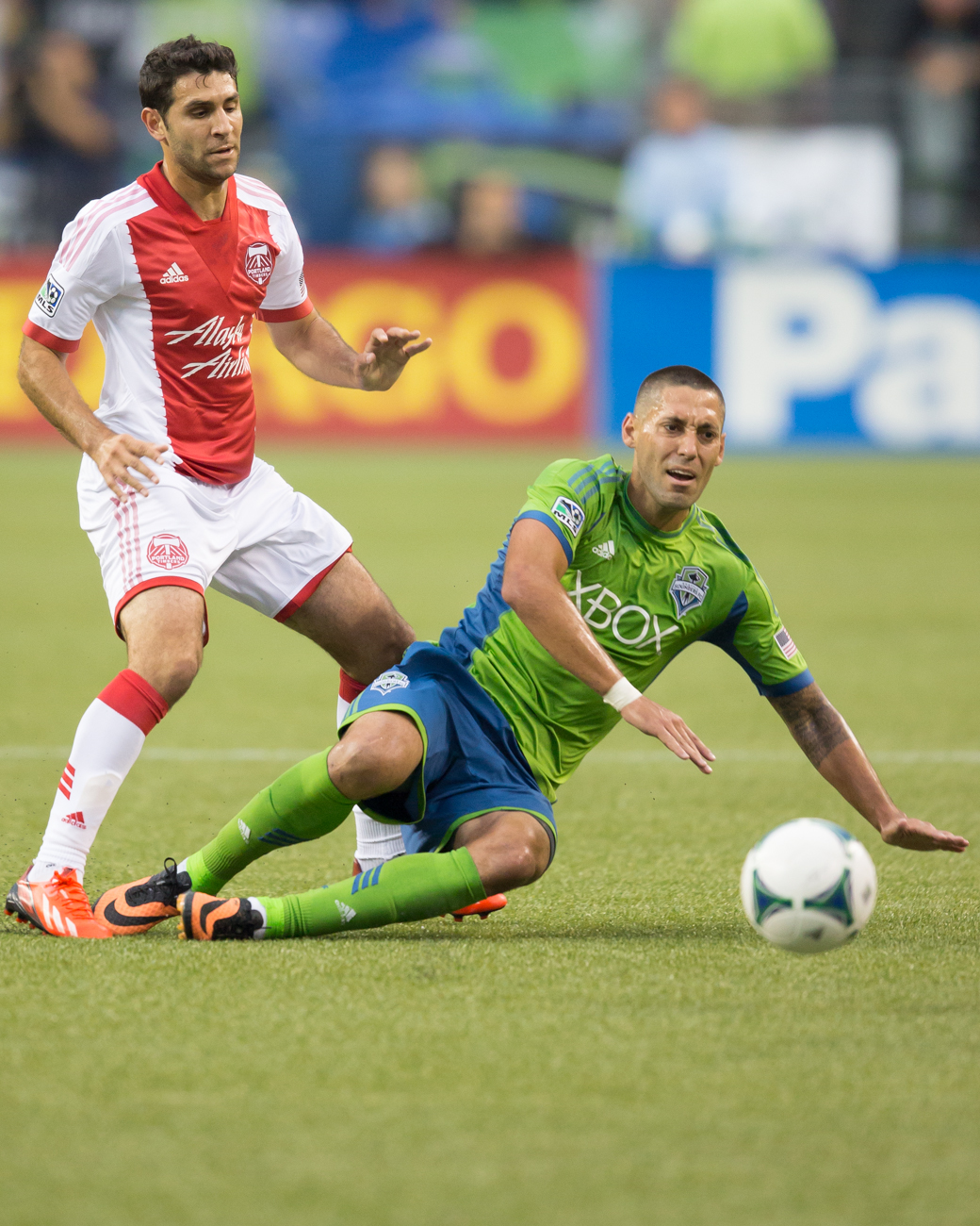 Dempsey gets tripped up by a Timbers player.