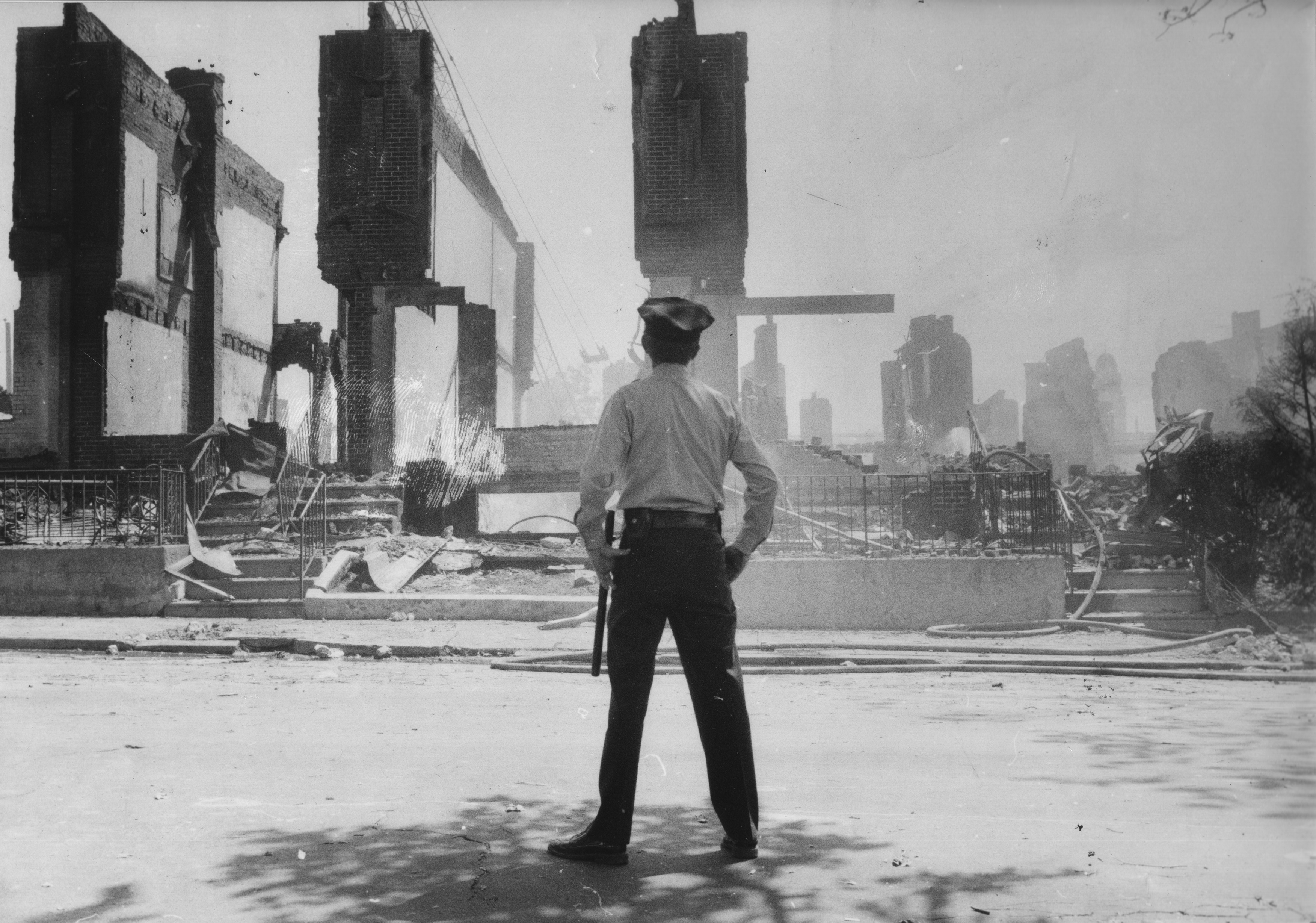 Following the fiery raid, a Philadelphia cop surveys the scene.