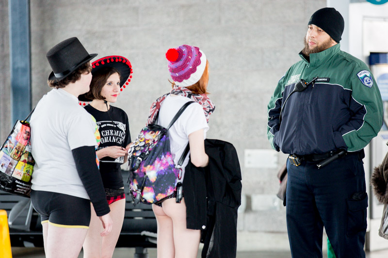 Pants-less riders talk with a Sound Transit security guard.