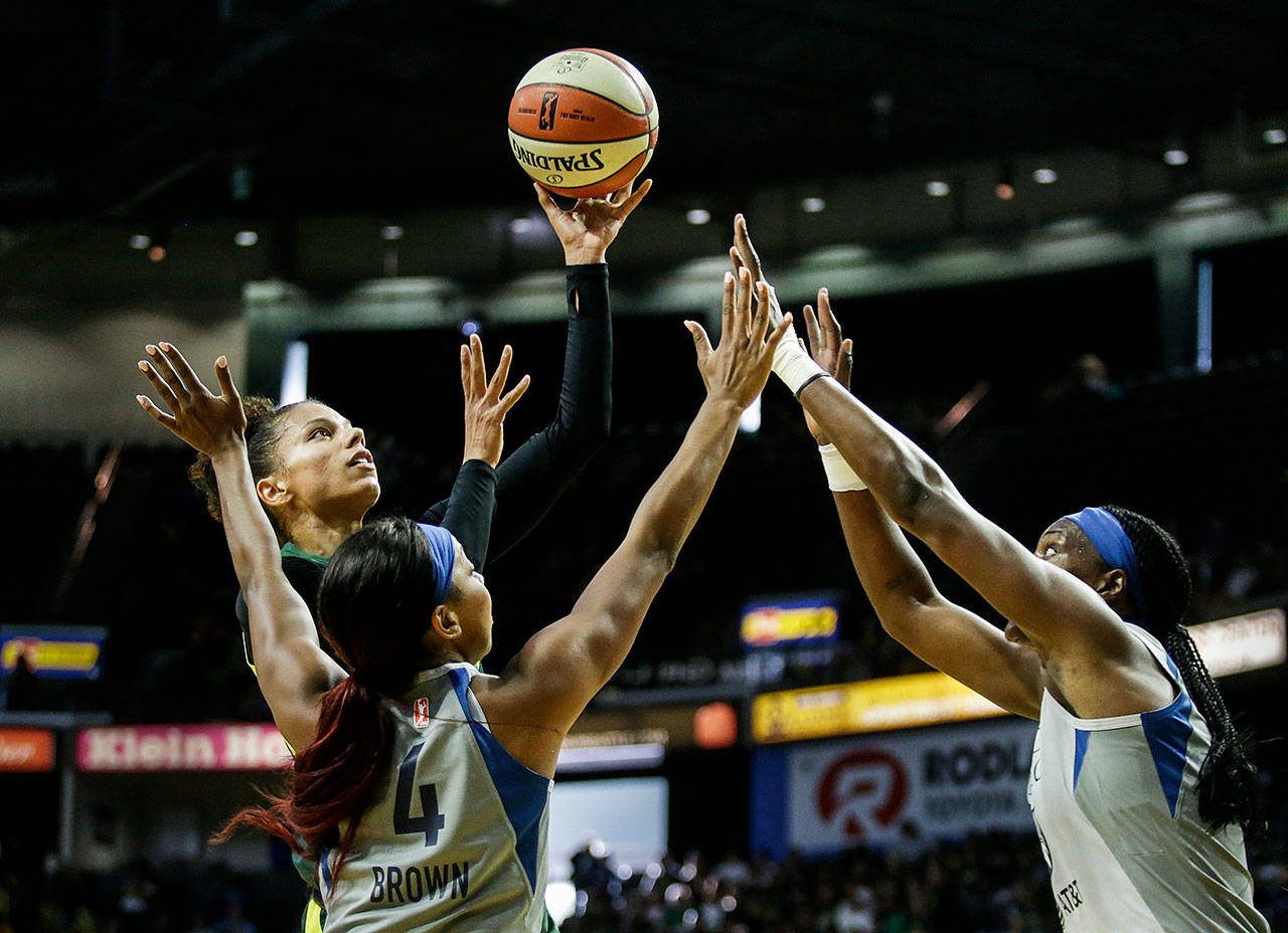 The Storm’s Alysha Clark shoots over two Lynx defenders during a game on June 4 at the Angel of the Winds Arena in Everett. (Andy Bronson / The Herald)