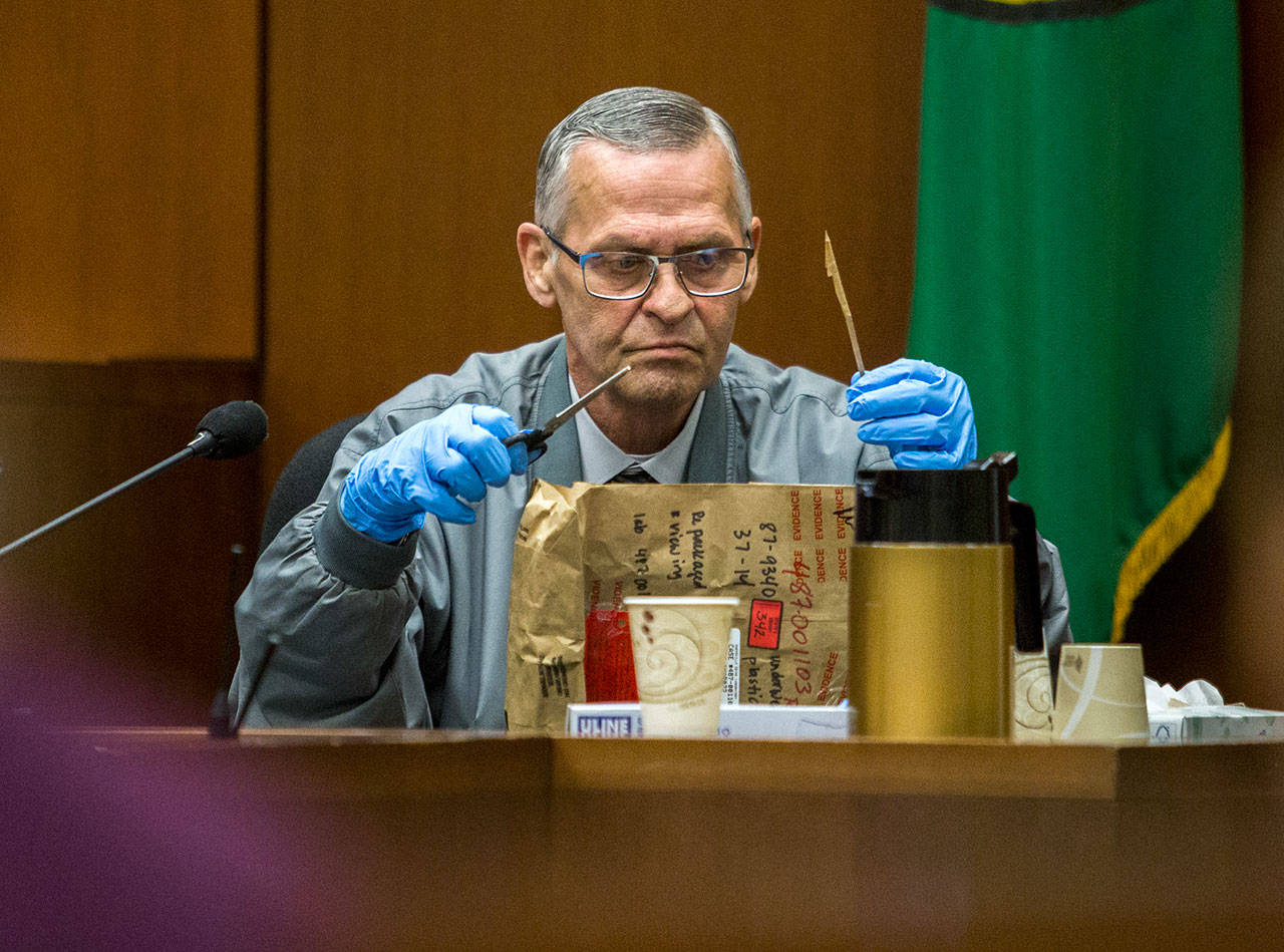 Witness Dave Willard opens an evidence bag during the trial for William Talbott II at the Snohomish County Courthouse on Tuesday in Everett. (Olivia Vanni / The Herald)
