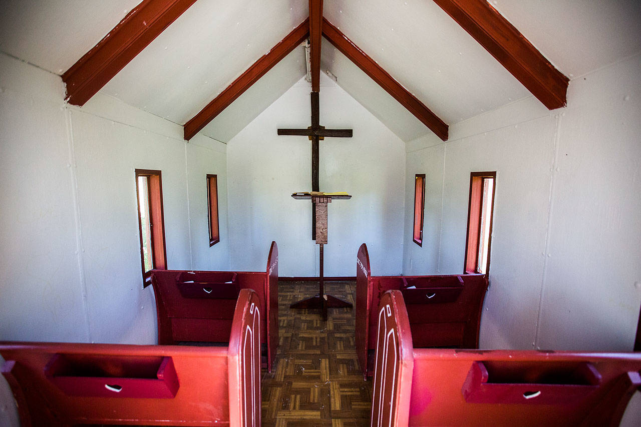 A white interior with four red pews at the Wayside Chapel on U.S. 2. (Olivia Vanni / The Herald)
