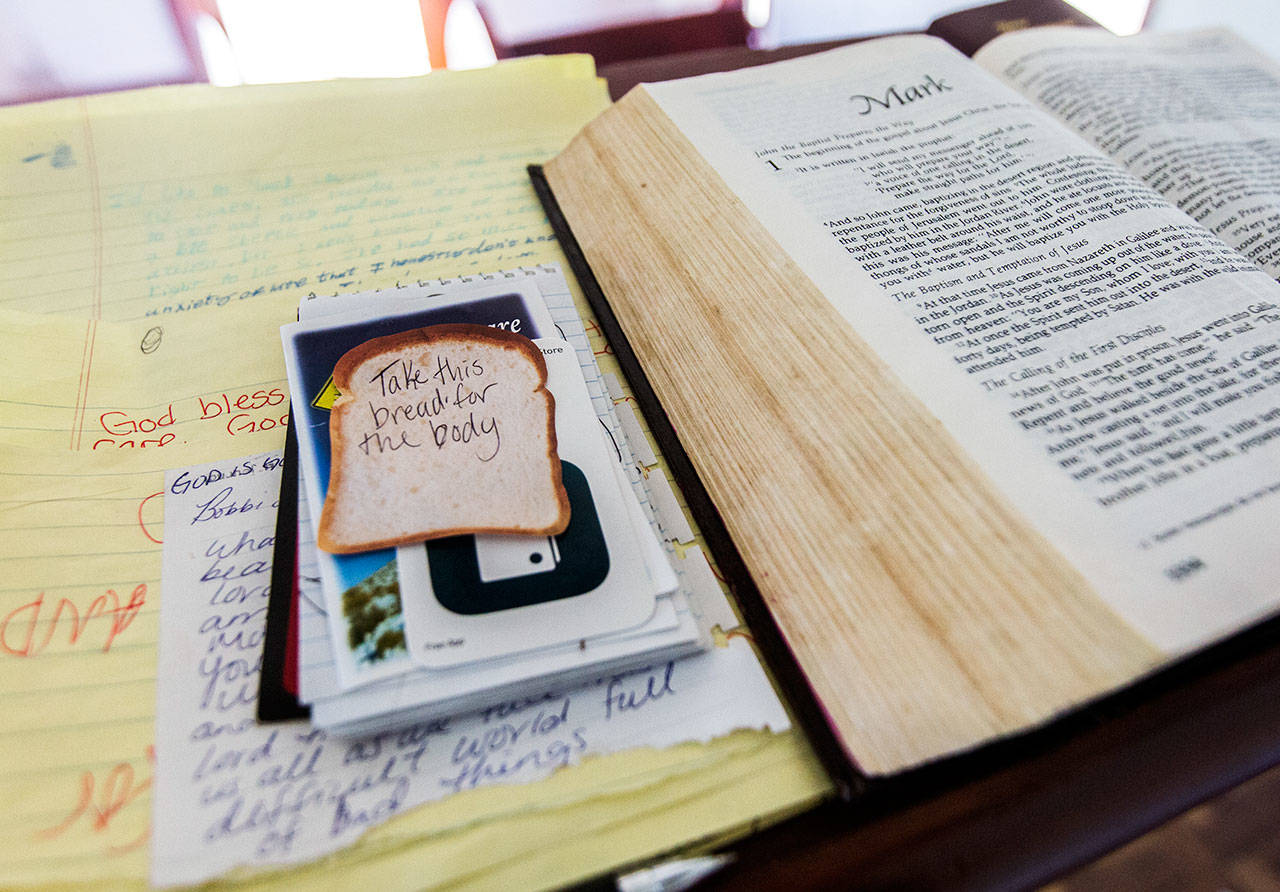 Handwritten notes and letters sit next to an open Bible at the Wayside Chapel. (Olivia Vanni / The Herald)