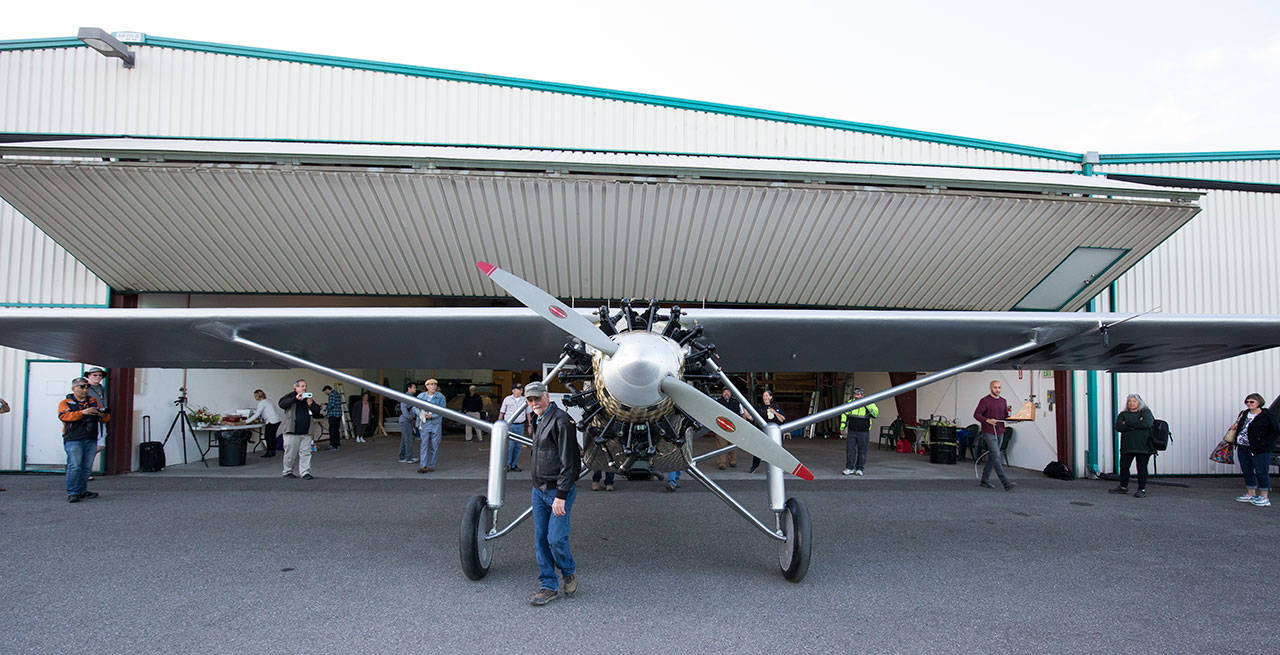 Pilot Ron Fowler helps pull John Norman’s replica of the Spirit of St. Louis out from its hangar at Arlington Municipal Airport on July 28. (Andy Bronson / The Herald)
