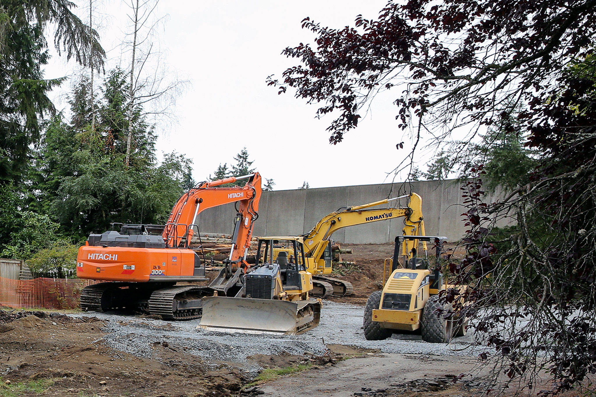 Heavy equipment is parked in former residential lots along I-5 in preparation for the light extension to Lynnwood slated to be completed in 2024. (Kevin Clark / The Herald)