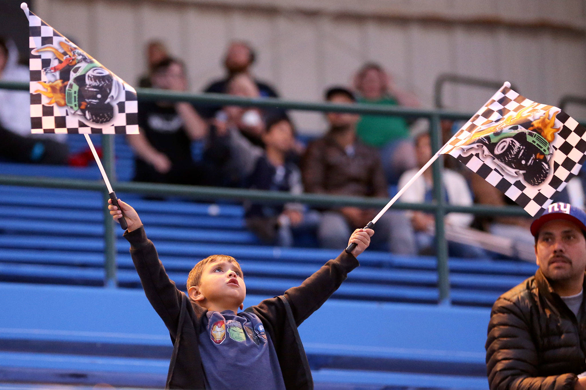A fan is enraptured by his flags during the monster truck show Friday evening during Evergreen State Fair at the Evergreen Speedway in Monroe. (Kevin Clark / The Herald)