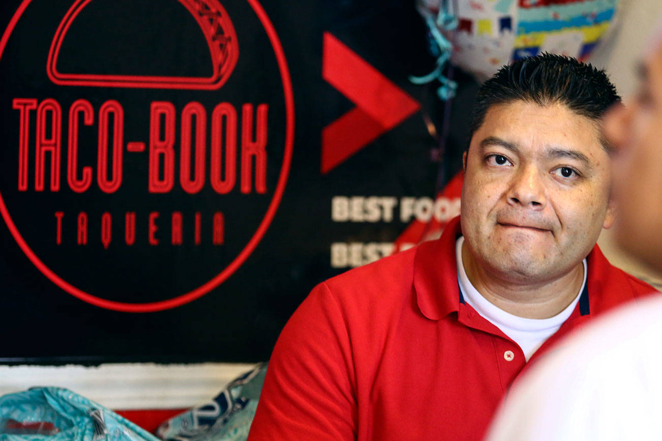 Rigoberto Bastida waits on a customer at Taco-Book in Everett. (Kevin Clark / The Herald)