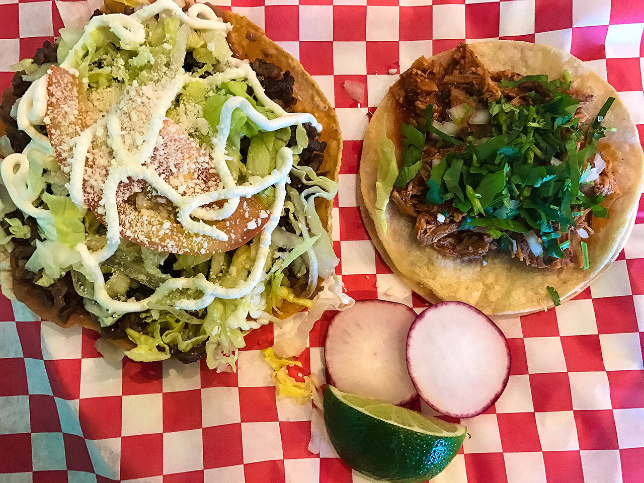 At Taco-Book, $4 buys a plate with a pork tostada and chicken taco, two of many menu options. (Andrea Brown / The Herald)