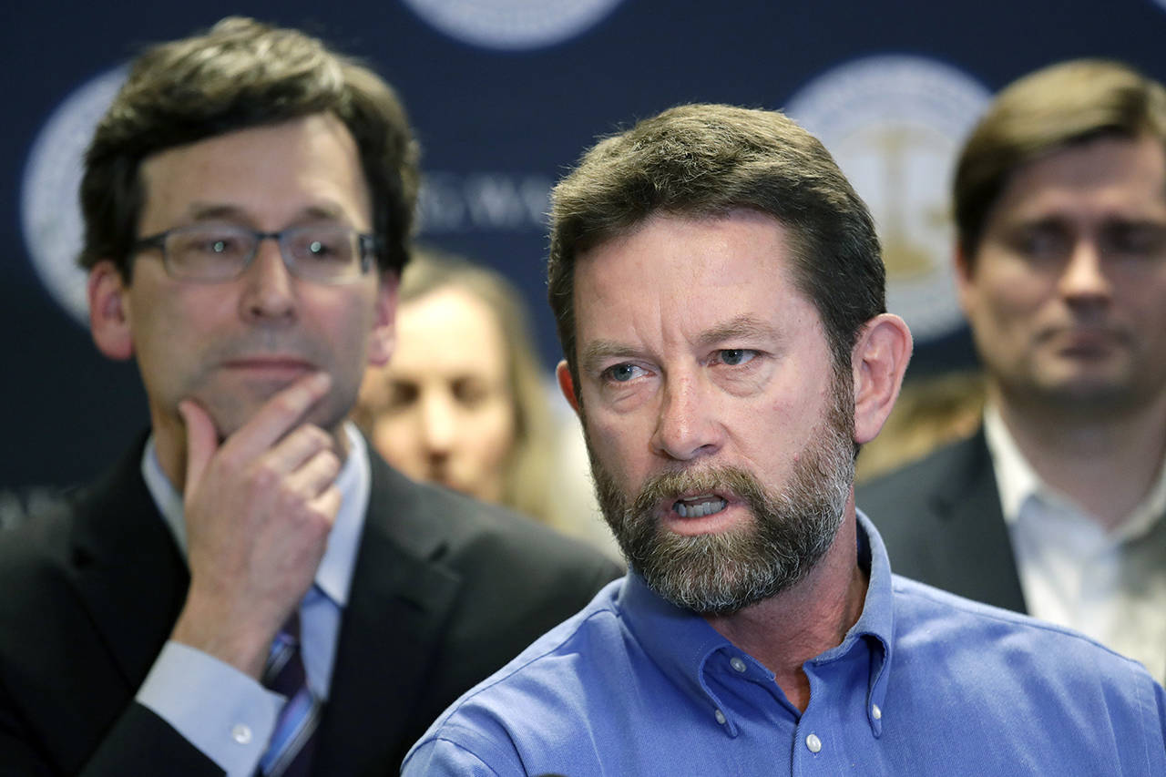Washington state Attorney General Bob Ferguson (left) looks on as Paul Kramer, the father of a teenage son who survived a mass shooting in Mukilteo, speaks at a news conference announcing legislation to combat mass shootings in the state, Thursday in Seattle. (AP Photo/Elaine Thompson)