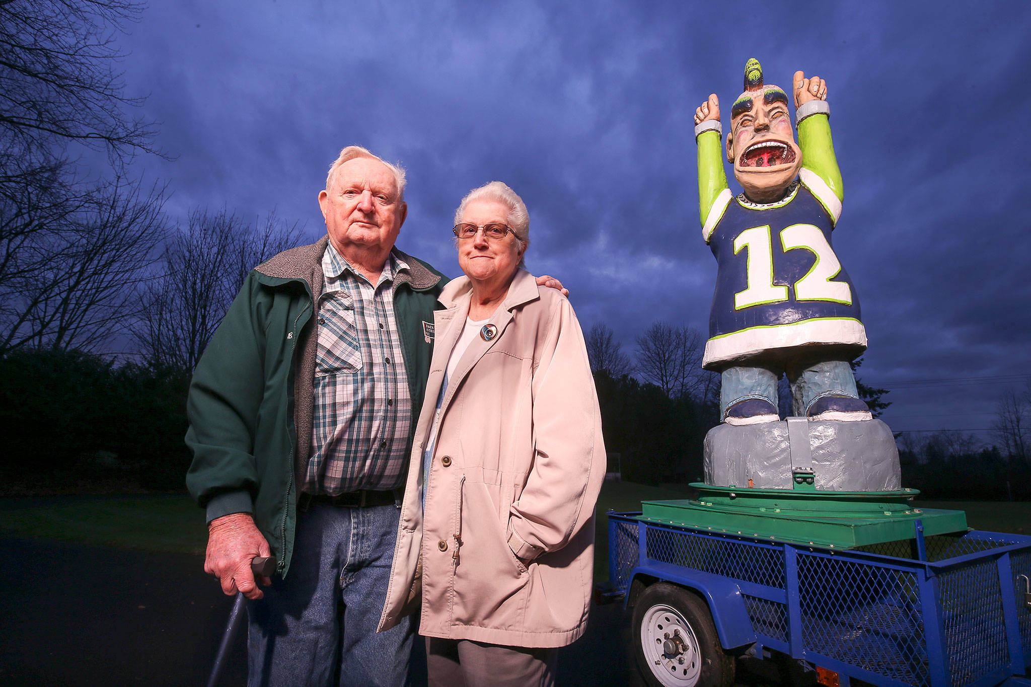 Bruce and Molly Walden with the 12th Man statue they named Ivan. Bruce bought the cedar statue for Molly’s 83rd birthday and had a custom trailer made to take it around Arlington and beyond. (Andy Bronson / The Herald)