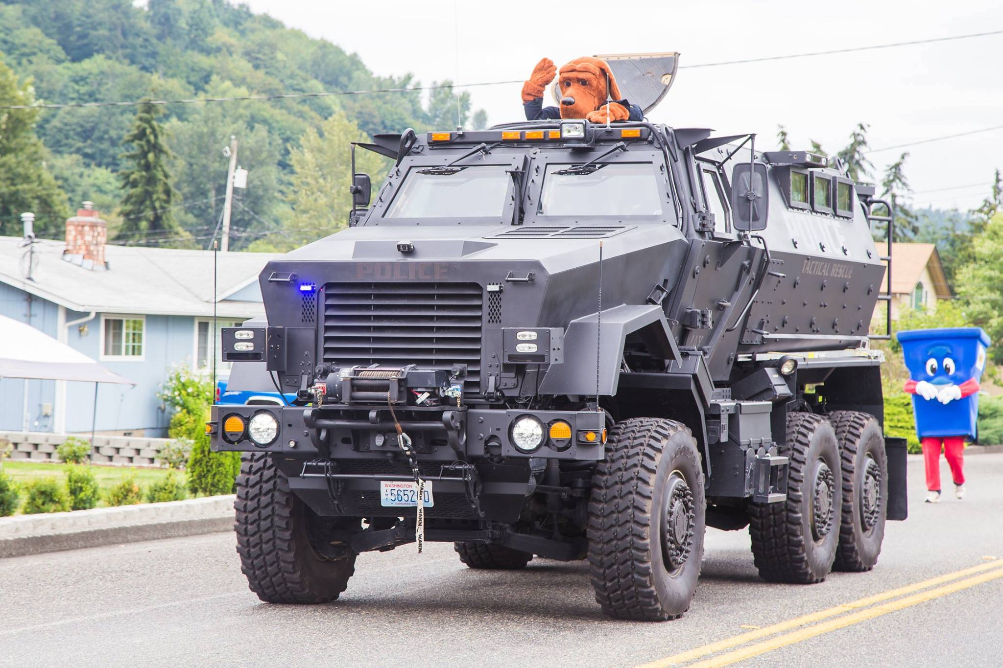 Snoqualmie Police Department houses a surplus military mine-resistant armored personnel carrier. They acquired it as part of an equipment sharing program from the federal government. It is utilized by a coalition of small-city police departments. It is seen here during a 2016 parade in Algona, one of the coalition member cities. From the Algona Police Department Facebook page