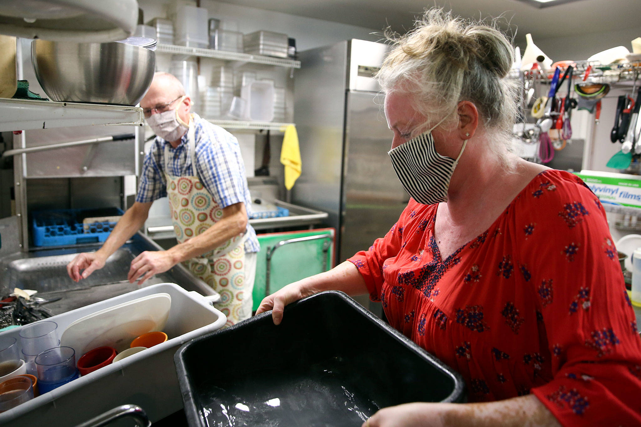 Brian Tilley (left) and Katie Dearman work the wash station Friday at Kate’s Greek American Deli in Everett. (Kevin Clark / The Herald)