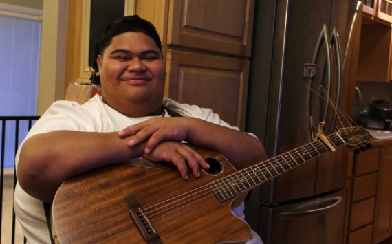 Decatur High School senior and “American Idol” contestant Iam Tongi sits at home on March 1. His father Rodney spent a bonus from his job as an electrician to buy Iam’s guitar. Alex Bruell / The Mirror