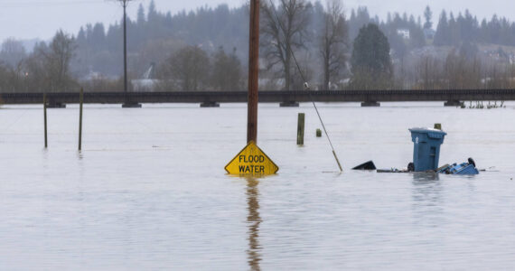 Floodwater from the Snohomish River partially covers a flood water sign on Thursday, Dec. 11, 2025 in Snohomish, Washington. (Sound Publishing photo)