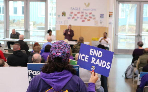 An attendee at the Feb. 21 town hall in Federal Way holds a sign calling for an end to ICE raids. Courtesy photo