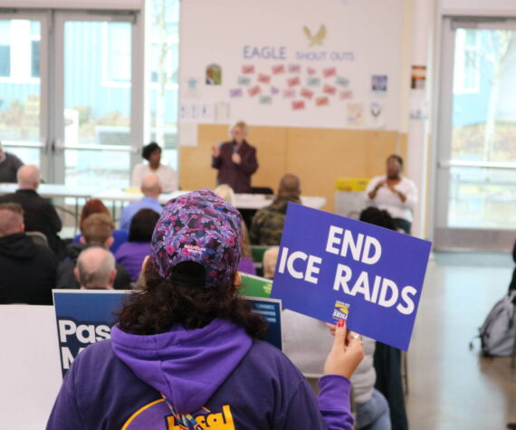 An attendee at the Feb. 21 town hall in Federal Way holds a sign calling for an end to ICE raids. Courtesy photo
