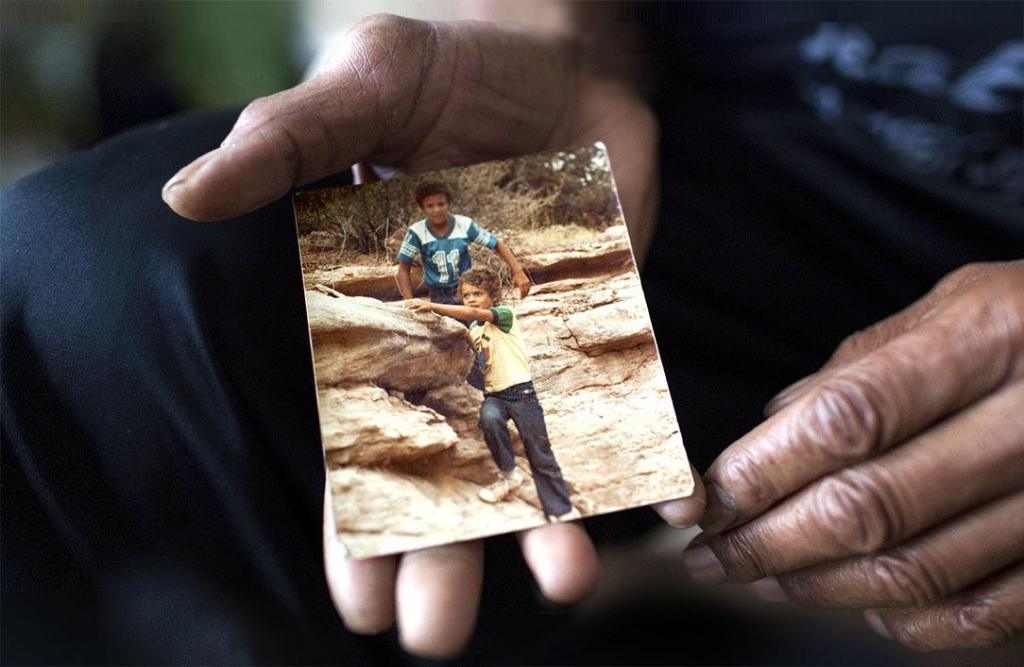 Bill Austin holds a photo of Nathan and his brother Forest. Photo by Jovelle Tamayo