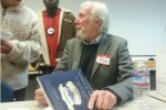 Former Seattle police chief Norm Stamper signs a copy of his book at the Not This Time meeting. Photo by Casey Jaywork.