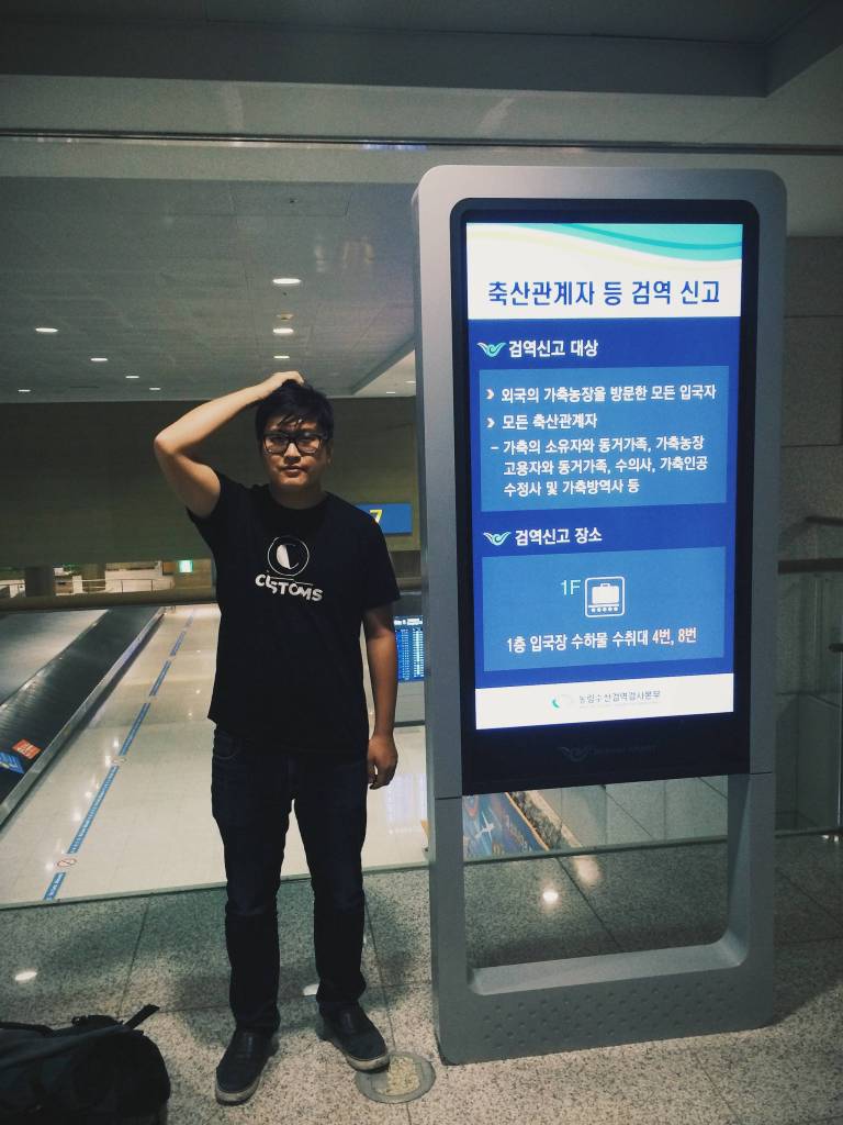 Allen Huang wearing his booking collective Customs&rsquo; shirt at airport customs. Courtesy of the artist
